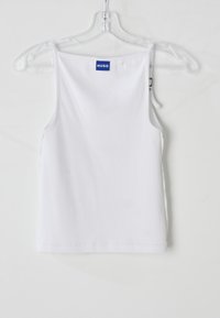 Valge puuvillane tank top õhukeste rihmadega, millel on ribakonstruktsioon ja sinine "HUGO" silt seljal. Lihtne ja liibuv disain.