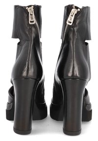 Black leather ankle boots with a chunky heel, featuring a back zipper, cut-out design, and textured finish.
