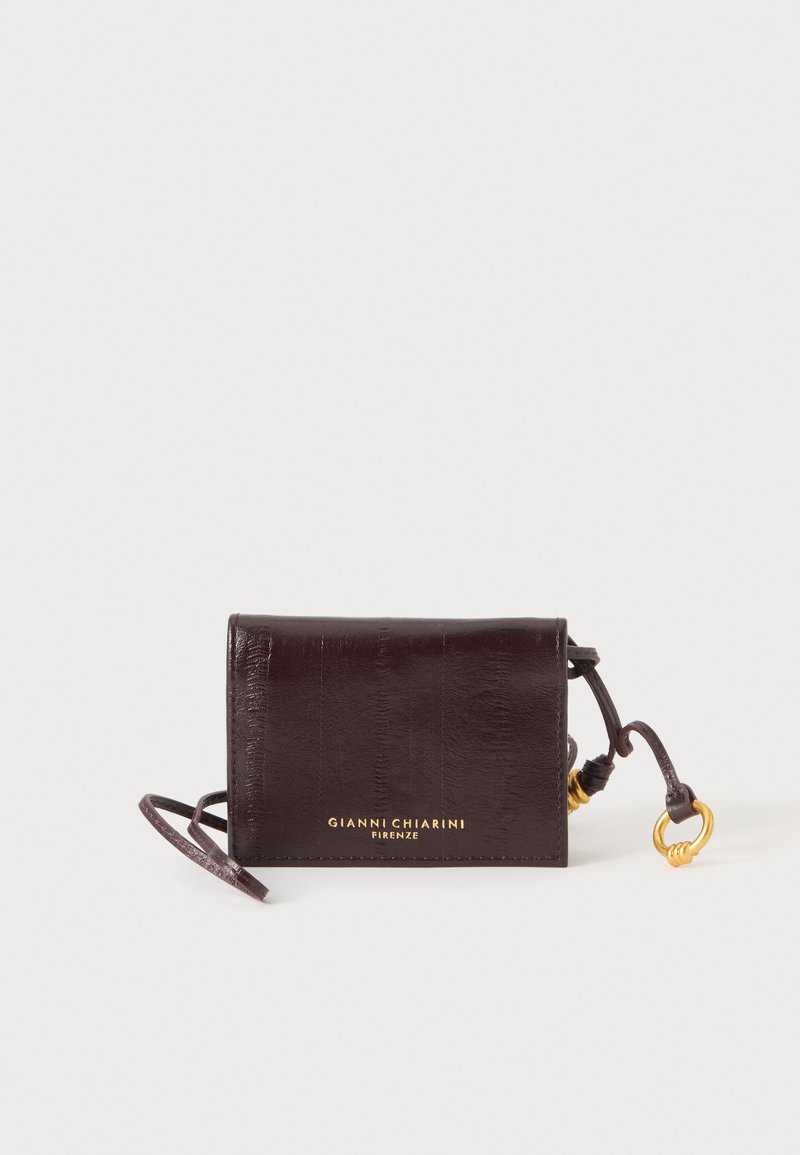 Portefeuille en cuir marron foncé avec une lanière pour poignet, détail anneau doré et logo « Gianni Chiarini Firenze » sur le devant.