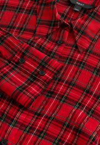 Rode geruite button-up shirt met zwarte knopen, gestructureerde stof en een gedetailleerd multikleurig ruitpatroon in verschillende breedtes.