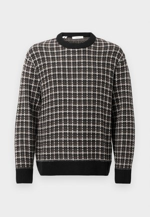 Black and white checkered crewneck sweater with ribbed cuffs and hem, displayed on a plain light background.