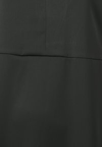 Dark gray fabric with a smooth texture, featuring a slight sheen. It includes seam details and a defined horizontal division.