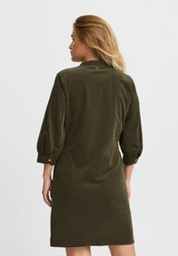 Khaki zielona sukienka o luźnym kroju, z rękawami 3/4 z detalami w postaci guzików oraz miękkim, teksturowanym materiałem.