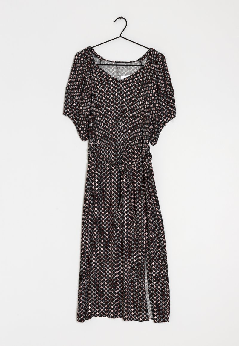 Robe noire avec un motif géométrique rouge et blanc, manches bouffantes courtes et taille cintrée. Tissu léger et fluide avec une fente.
