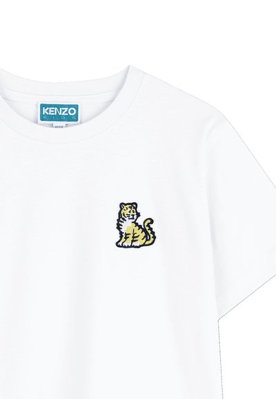 T-shirt en coton blanc à col rond, avec un petit tigre brodé en jaune et noir sur le côté gauche de la poitrine.