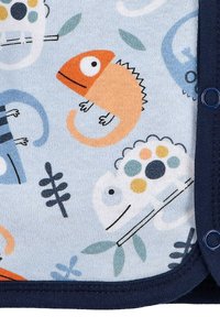 Helles blaues Stoffmuster mit Chamäleonmotiven in Orange, Grün und Weiß, mit marine-blauen Abschlüssen und blauen Druckknöpfen am Rand.