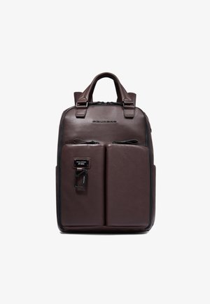 Mochila de cuero marrón con dos bolsillos frontales, asas superiores y cierre de cremallera. Presenta el logotipo de la marca en el frente y detalles metálicos plateados.