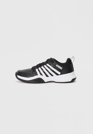 Chaussure de sport noire avec des rayures blanches, en matériau synthétique, avec un dessus texturé, un bout rond et une semelle rembourrée. Marque sur le côté.