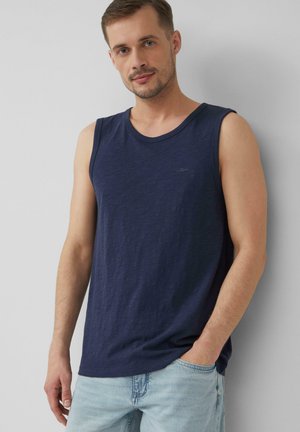 T-shirt sans manches bleu marine en tissu doux, avec un col rond et un petit logo sur le devant, associé à un short en denim clair.
