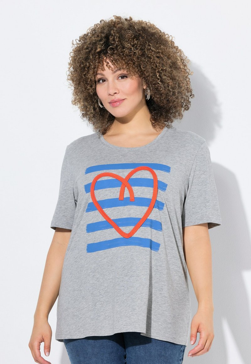 Camiseta de algodón gris con un diseño gráfico de rayas azules y un corazón naranja. Manga corta, ajuste relajado, cuello redondo.