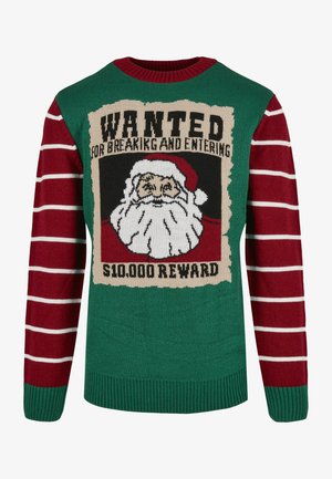 Megzta megėklė su žalia kūno dalimi, raudonai dryžuotomis rankovėmis ir grafika su Šventuoju Kalėdų Seneliu bei tekstu "IEŠKOMA" ir "$10,000 ATLYGIS."