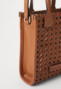 Rjava tkana torbica iz usnja, ki se ponaša z teksturiranim dizajnom, elegantno obliko in ojačanimi ročaji s kontrastnim šivanjem.