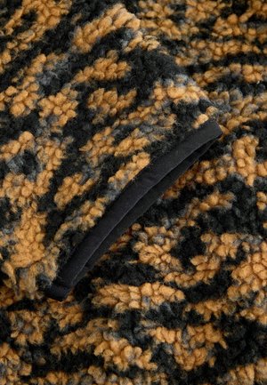 Švelni, tekstūruota medžiaga juodos, garstyčių ir pilkos spalvų su raštuotu dizainu. Krašte yra juoda apdaila.