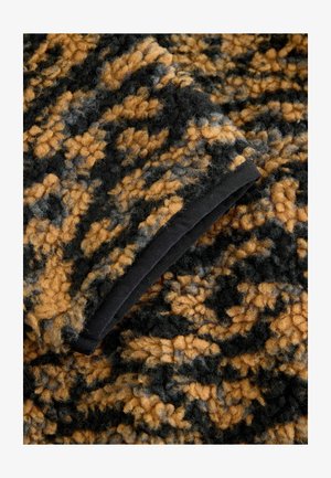 Fuzzy, tekstureret stof i sort, sennep og grå med et mønstret design. Har en sort kant langs kanten.