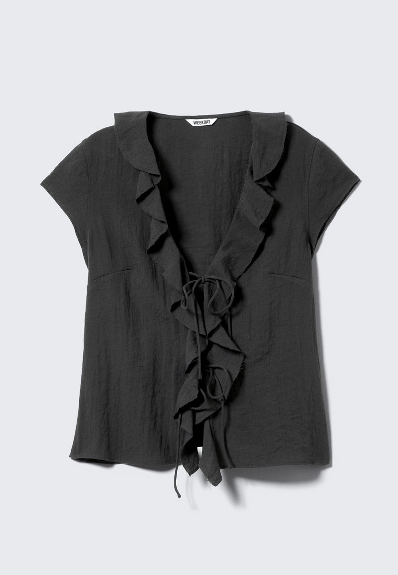 Blouse à manches courtes gris foncé avec un col à volants et un détail noué à l'avant, fabriquée dans un tissu léger à la texture douce.