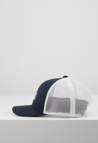 Casquette de baseball bleu marine avec un dos en maille blanche, visière incurvée et un petit patch logo à l'avant. Présente un design structuré.
