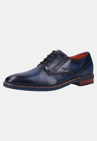 Chaussure en cuir navy avec une texture lisse, bout rond, design structuré, fermeture à lacets, et accents marron sur la semelle.