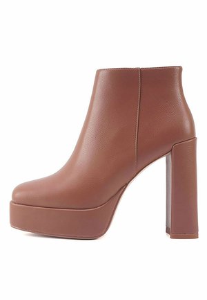 Brown leather ankle boot with a platform sole and block heel, featuring a smooth texture and sleek silhouette. No visible hardware or accents.