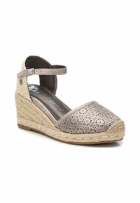Sandalias de cuña beige con parte superior de cuero perforado, tira al tobillo y suela de yute trenzado. Punta redondeada y detalles texturizados en el tacón.