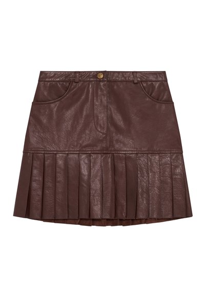 Bruine leren plissérok met een hoge taille, voorzien van twee voorzakken en een gouden knoop bij de tailleband. Plissé's lopen uit vanaf de zoom.