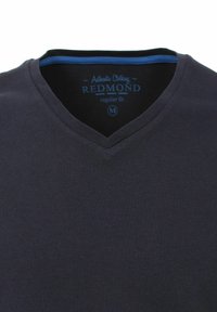 Mørkeblå v-hals t-shirt lavet af blødt stof. Har en kontrastfarvet blå inderside af halsbåndet og trykt mærke med størrelse M. Regular fit.