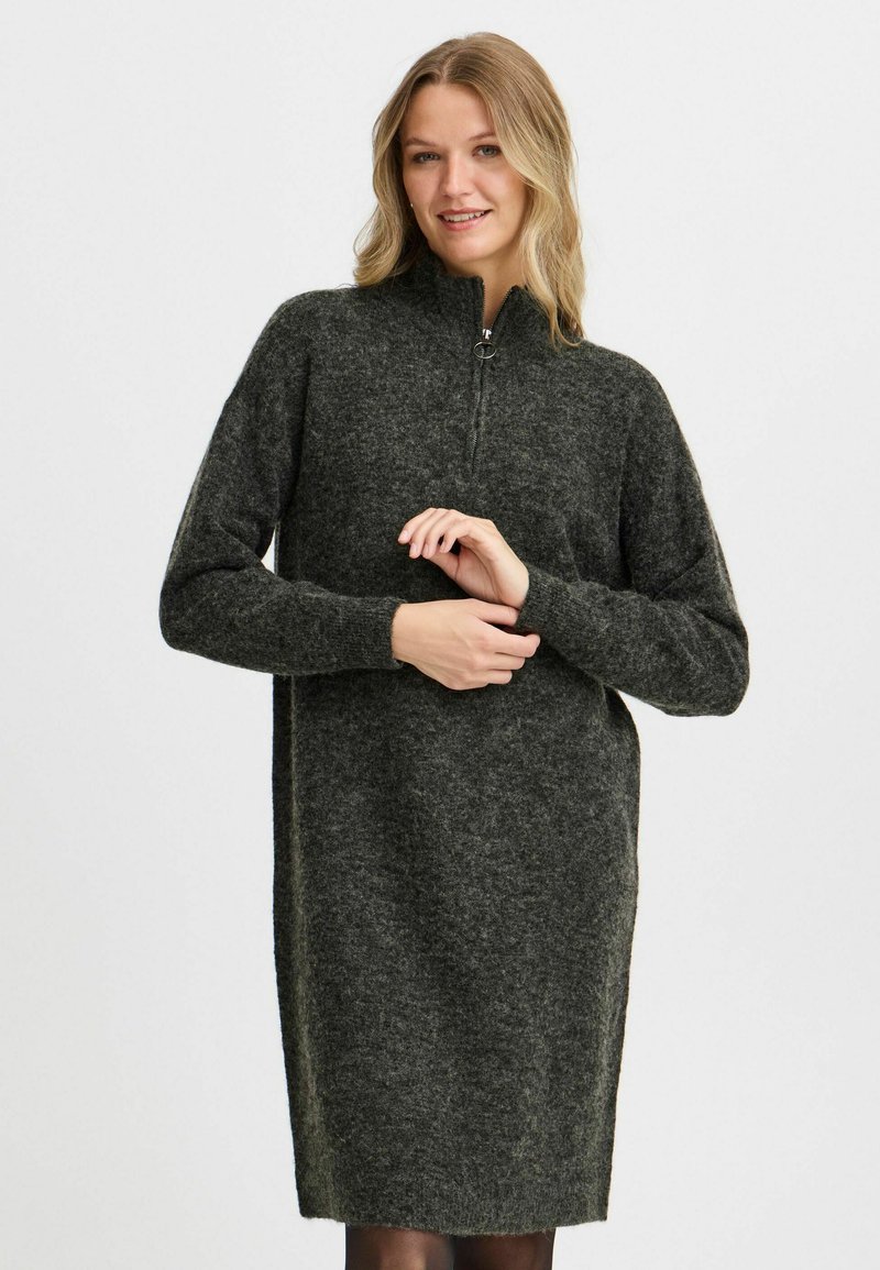 Abito in maglia con colletto alto, maniche lunghe e zip frontale. Texture grigia scura con un aspetto morbido e peloso. Silhouette semplice e rilassata.