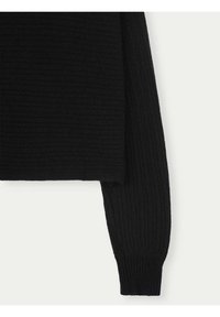 Svart ribbad tröja med långa ärmar och avslappnad passform. Texturen är mjuk, med ett brett ribbmönster och åtsittande ärmslut.