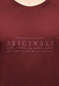 Μπορντό φούτερ με στρογγυλή λαιμόκοψη και ανάγλυφο κείμενο: "Nineteen Ninety Originals 1990 Παρουσιάζεται από τους Jack & Jones."