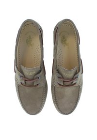 Scarpe da barca in suede marrone con design mocassino, lacci in pelle marrone e occhielli laterali. Presentano una soletta forata e un sottile dettaglio del logo.