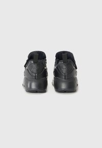 Sapatos atléticos pretos com acabamento texturizado, parte superior em malha, solas de borracha e alças na parte traseira; apresentam a marca na parte do calcanhar.