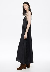 Mustav aluskleit pitsääristega, voolav kangas ja spagettiinirihmad, kombineeritud pruunide pahkluu saapadega. Lihtne ja elegantne disain.