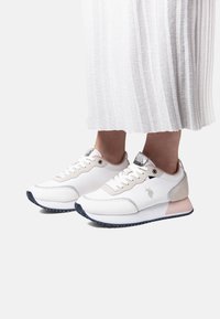 Białe sneakersy z jasnoszarymi akcentami, teksturowana tkanina, okrągły nosek, sznurowany fason, z logo i kontrastującą gumową podeszwą.