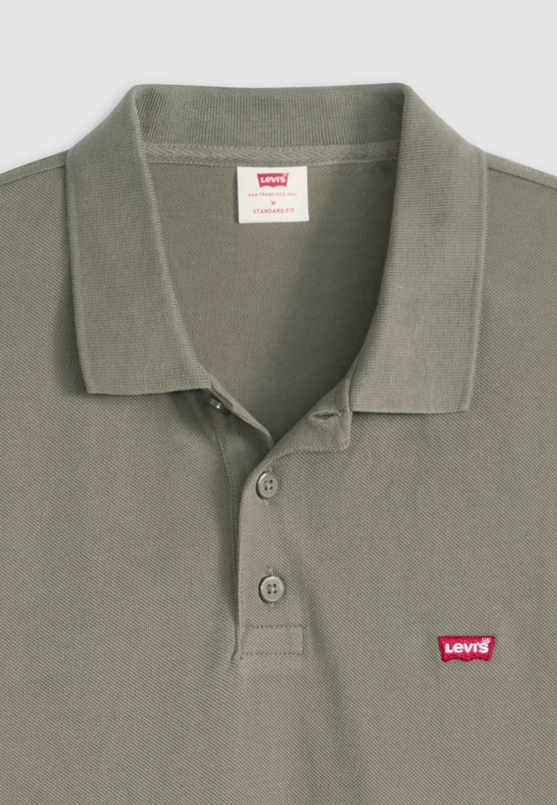 Polo Levi's vert olive avec col, deux boutons et écusson logo Levi's rouge sur la poitrine.