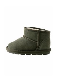 Olivgrüne Wildleder-Stiefelette mit einem weichen Futter aus Fell, niedrigem Profil, runder Zehenpartie und kontrastierenden Nähten. Flache Gummisohle.