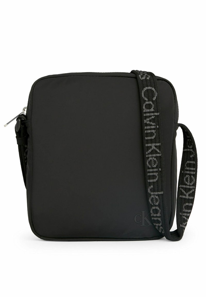 Borsa a tracolla in nylon nero con forma quadrata, chiusura con zip e una tracolla decorata con il logo "Calvin Klein Jeans".