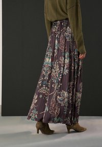 Vzdušná tmavě fialová maxi sukně s květinovým vzorem v tyrkysové a krémové barvě, s elastickým pasem a lehkou látkou. Nositelná s kotníkovými botami.