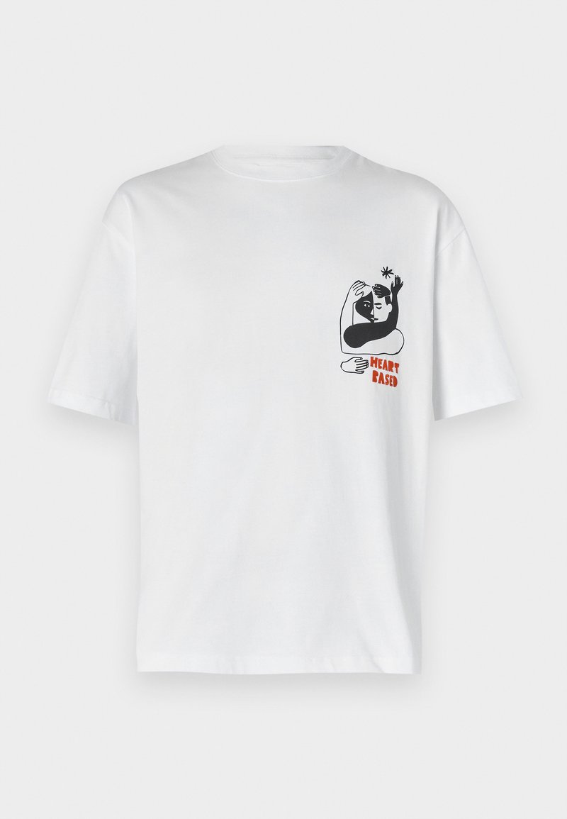 Witte katoenen t-shirt met een zwart-wit grafiek van twee figuren die omarmen, met daaronder de tekst "HEART BASED" in het rood. Korte mouwen.