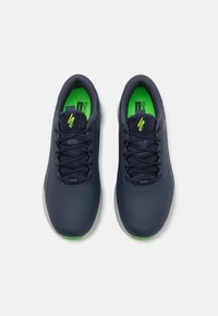 Pantofi sport marini cu un material superior sintetic neted, accente verzi pe branturi și sistem de șireturi tradițional; vârf rotunjit și talpă ușoară.