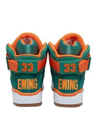 Grønne og orange høje sneakers med hvide såler, med "EWING" og "33" broderet på hælene og en rem om anklen.