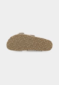 Semelle de sandale avec un motif de bande de roulement géométrique circulaire, présentée horizontalement sur un fond blanc uni.