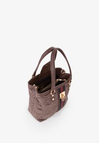 Bolso de mano texturizado marrón con patrones florales bordados, doble asa superior, herrajes en tono dorado y un bolsillo interior con cremallera.