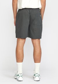 Grijze shorts met een elastische tailleband, een enkele achterzak en een casual pasvorm. Het materiaal lijkt lichtgewicht met een gladde textuur.