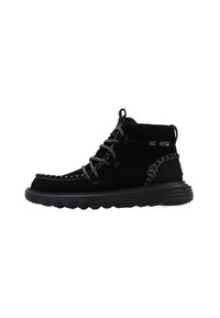Botines de ante negro que presentan un upper texturizado, costuras en contraste y una suela de goma resistente con un patrón ondulado. Diseño de cordones.