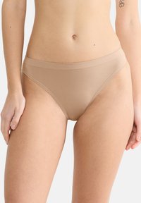 Beige nahtloser Bikini-Unterwäsche mit einer weichen, glatten Textur und einem breiten elastischen Bund, der für Komfort und eine schlanke Passform entwickelt wurde.