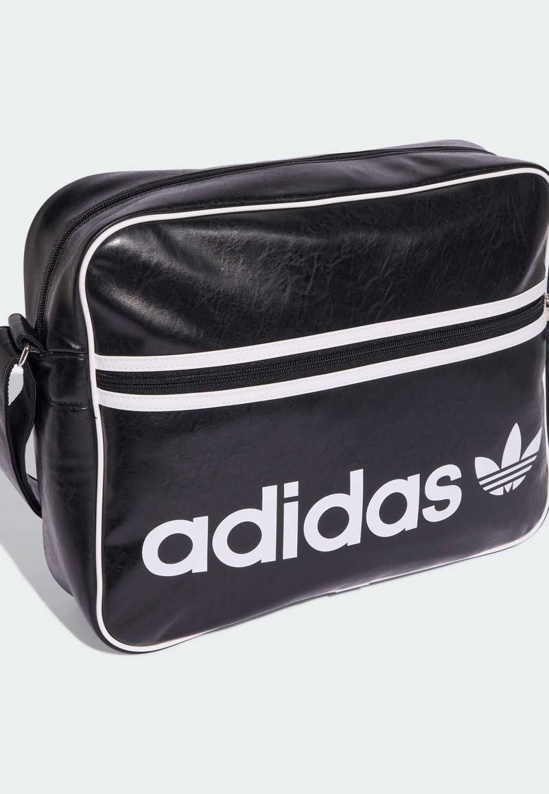Black synthetic bag with white accents, rectangular shape, single zippered compartment, large "adidas" logo, and three stripes logo detail.