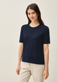 Mörkblå, kortärmad t-shirt med rund halsringning. Tillverkad av slätt material med en klassisk passform, passar bra till byxor i neutrala färger.