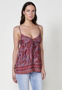 Camisola rossa con motivo paisley, dotata di spalline sottili regolabili, un corpino arricciato e un dettaglio con nodo nella parte anteriore; presenta accenti blu e crema.