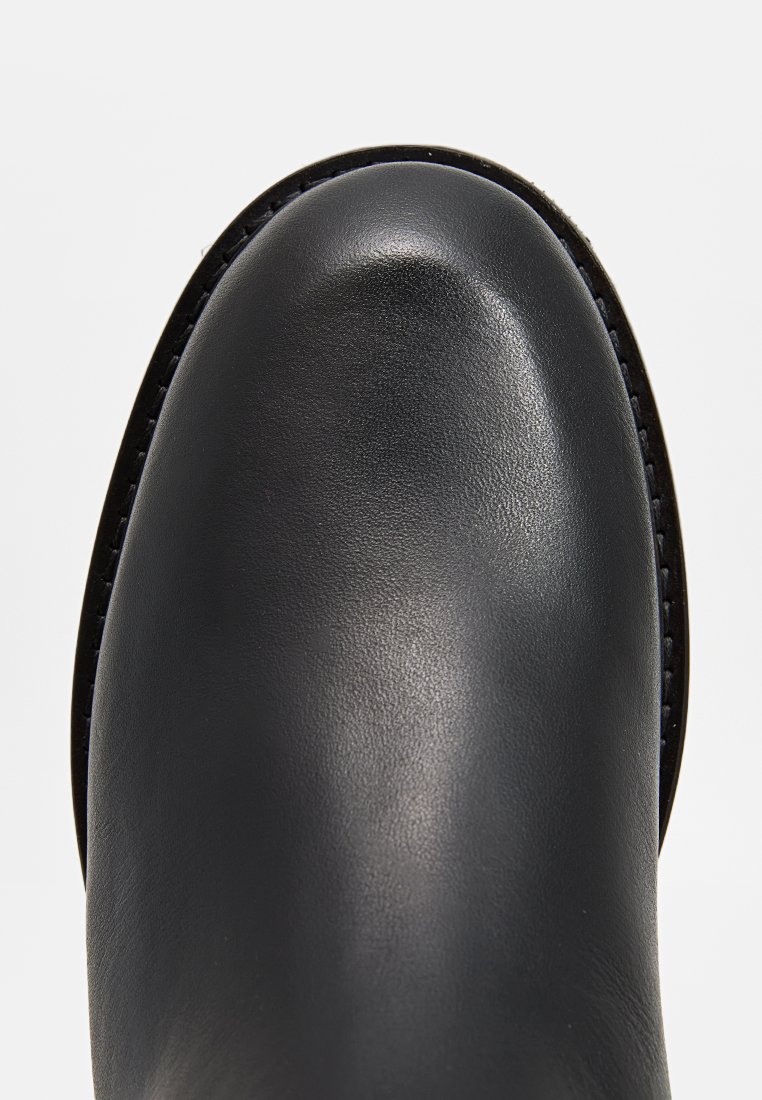 Schwarzer Leder-Stiefelette mit einer glatten, runden Zehenpartie, dezenten Nähdetails und einem niedrigen, robusten Absatz.