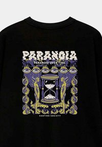 Camiseta negra con un diseño gráfico que incluye la palabra "PARANOIA" en blanco, un reloj de arena, dos figuras y un fondo morado con llamas amarillas.