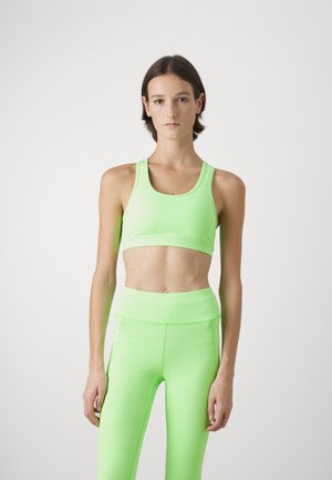 Neon groene sportbeha en legging set gemaakt van soepel, rekbaar materiaal. Heeft een aansluitend ontwerp met een hoge tailleband op de leggings.